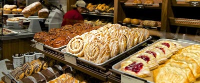 A picture of a Panera bakery with a selection of pastries, cookies and bagels on display.