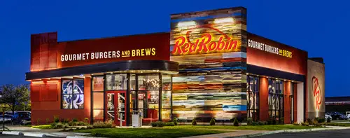Picture of a Red Robin restaurant exterior view against the backdrop of a dark blue twilight sky.